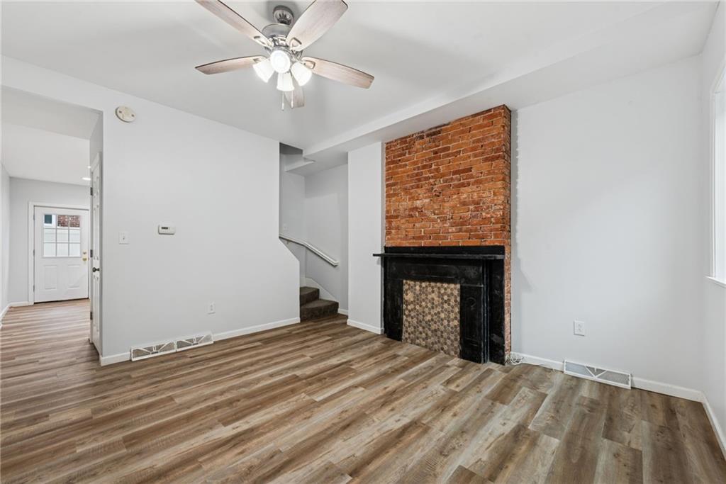 4416 Woolslayer Way Pittsburgh, PA 15224 - Photo 5 of 21 a view of empty room with a fireplace and wooden floor