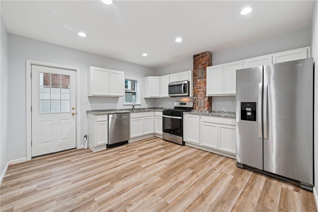 4416 Woolslayer Way Pittsburgh, PA 15224 - Photo 6 of 21 a kitchen with white cabinets and stainless steel appliances