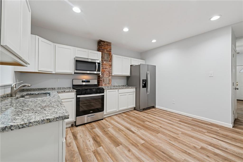 4416 Woolslayer Way Pittsburgh, PA 15224 - Photo 7 of 21 a kitchen with granite countertop a refrigerator and a stove top oven
