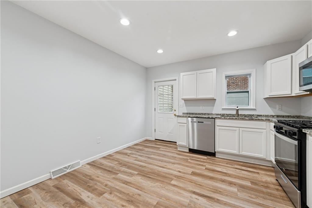 4416 Woolslayer Way Pittsburgh, PA 15224 - Photo 9 of 21 a kitchen with granite countertop a stove top oven and sink