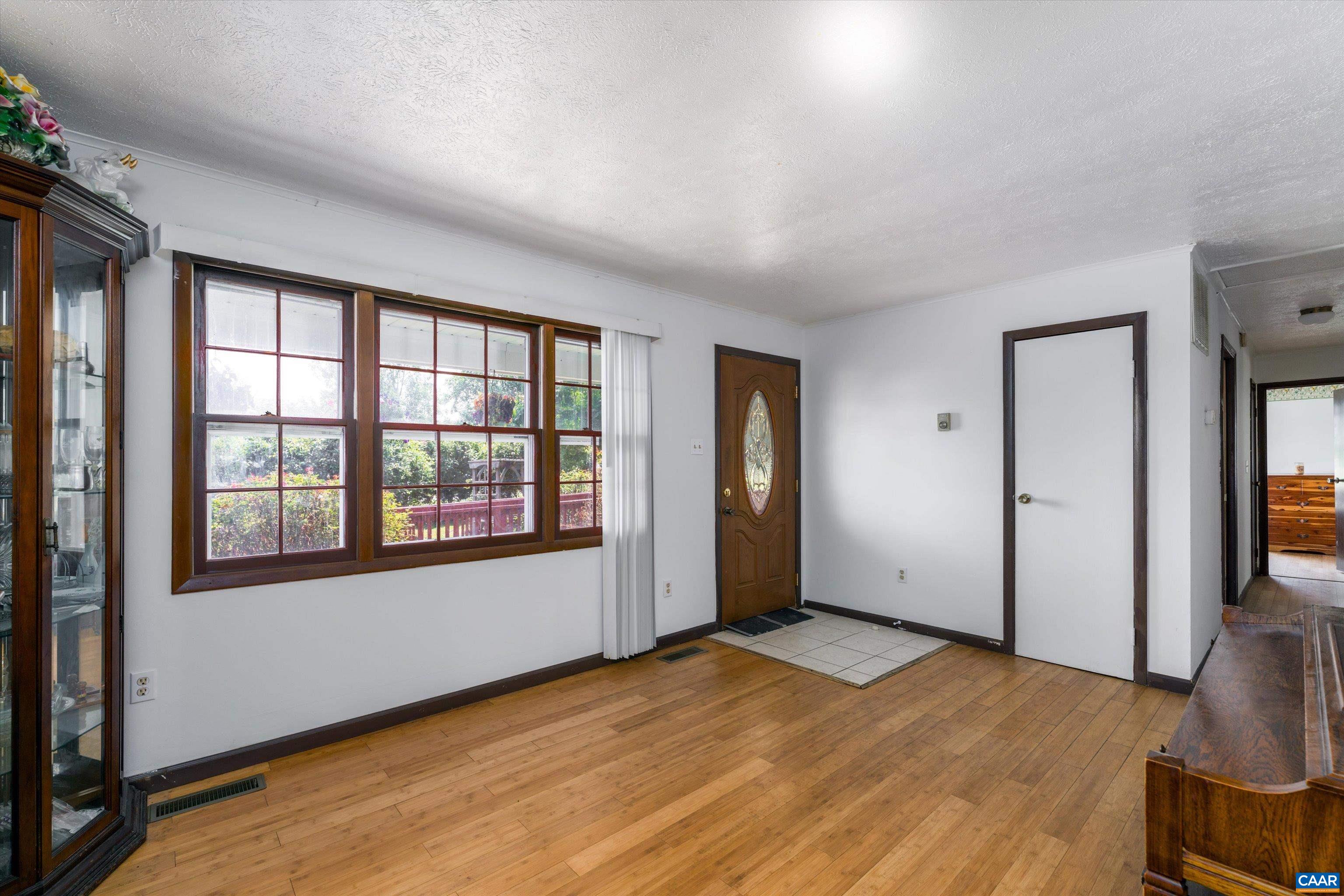 579 Miller Mountain Road Stanardsville, VA 22973 - Photo 8 of 27 an empty room with wooden floor and windows