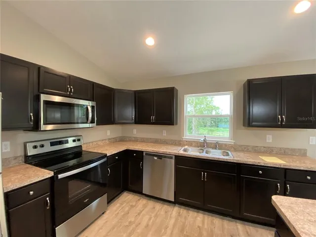a kitchen with a sink and steel appliances