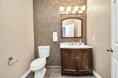 a bathroom with a toilet a sink and mirror