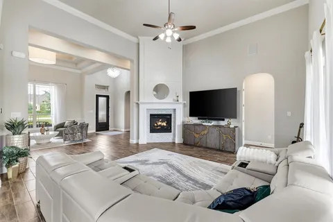 a living room with furniture a flat screen tv and a chandelier