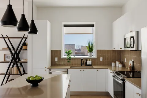 a kitchen with stainless steel appliances kitchen island a stove a sink a counter space and cabinets