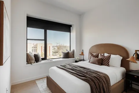 a bedroom with a bed and a large window