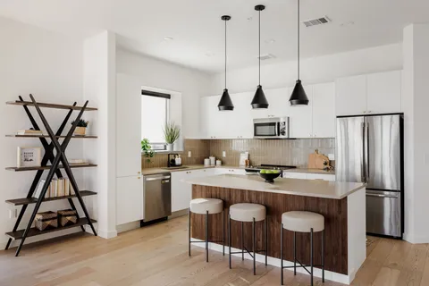 a kitchen with stainless steel appliances granite countertop a sink a stove and a refrigerator