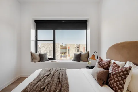 a bedroom with a large bed and a large window