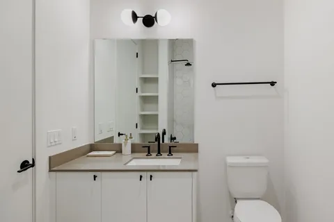 a bathroom with a toilet sink and mirror
