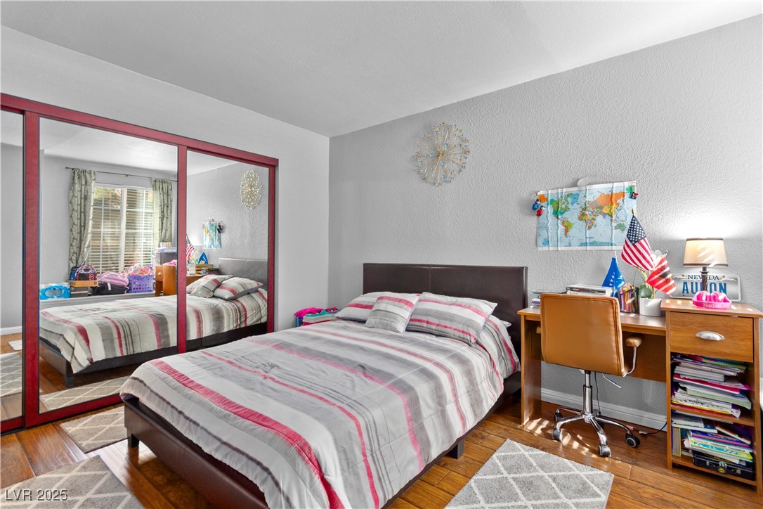 9325 West Desert Inn Road, Unit 141 Las Vegas, NV 89117 - Photo 10 of 30 Bedroom featuring a textured wall, wood-type flooring, and an office area
