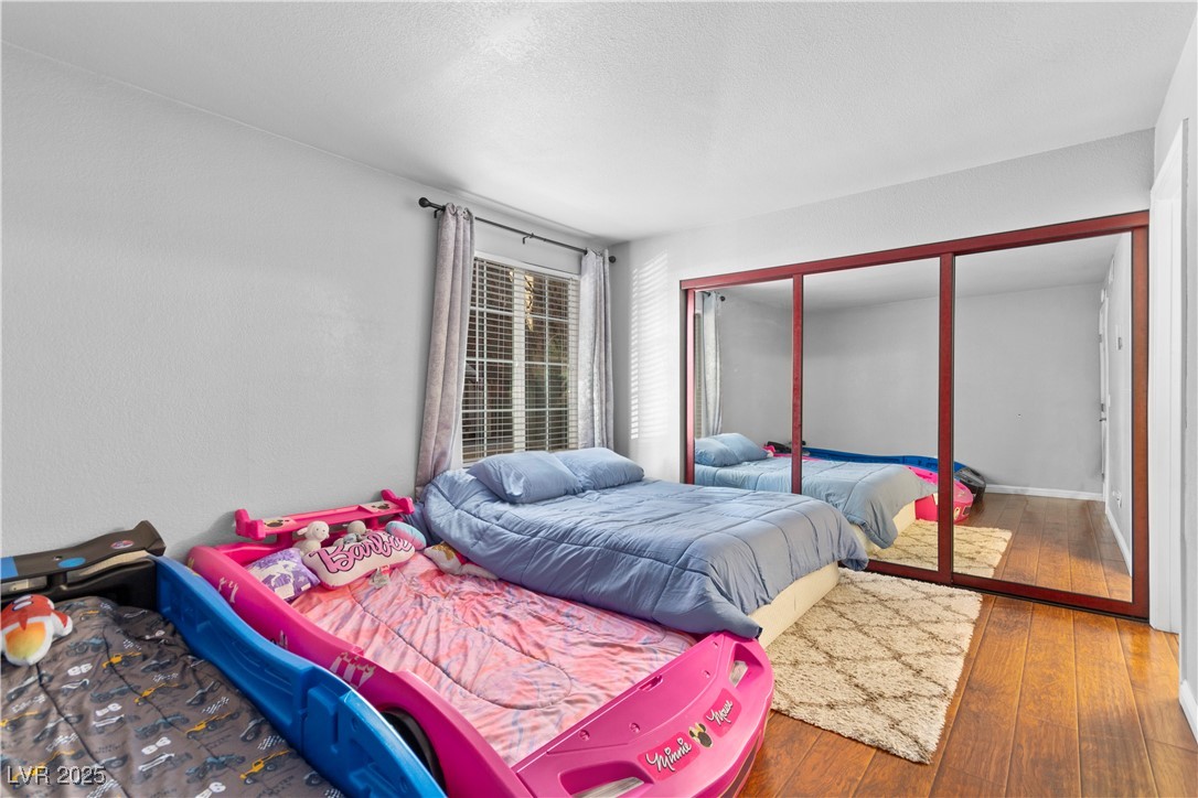 9325 West Desert Inn Road, Unit 141 Las Vegas, NV 89117 - Photo 7 of 30 Bedroom with a closet, hardwood / wood-style flooring, and a textured ceiling