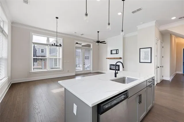 a kitchen with stainless steel appliances granite countertop a sink a stove and a wooden floor