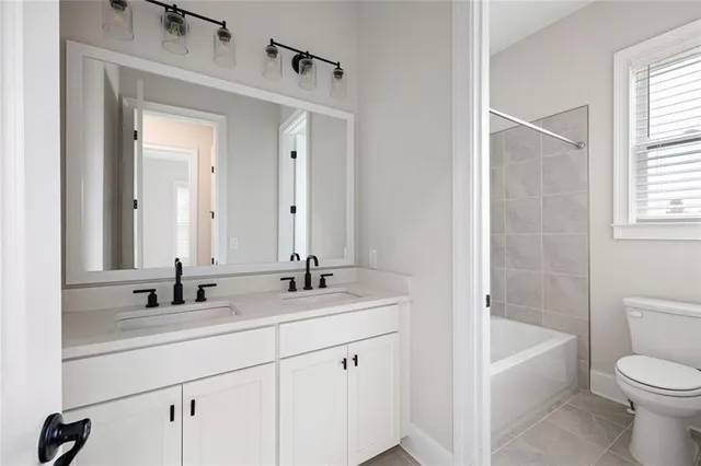 a bathroom with a bathtub shower sink vanity and toilet