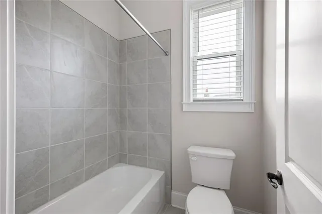 a white toilet sitting next to a bath tub