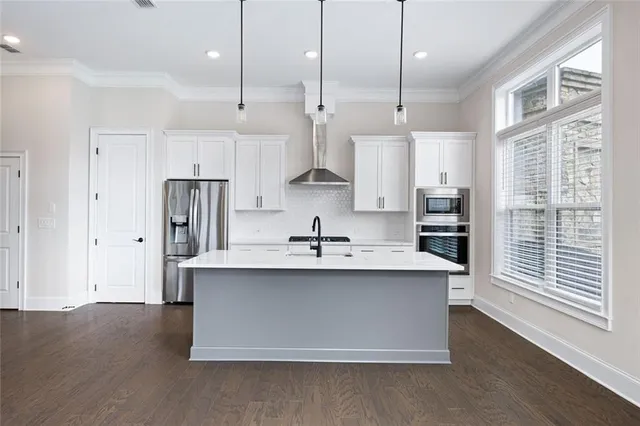a kitchen with kitchen island a sink stove and refrigerator
