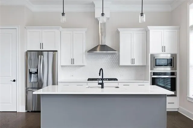 a kitchen with stainless steel appliances a sink a refrigerator and cabinets