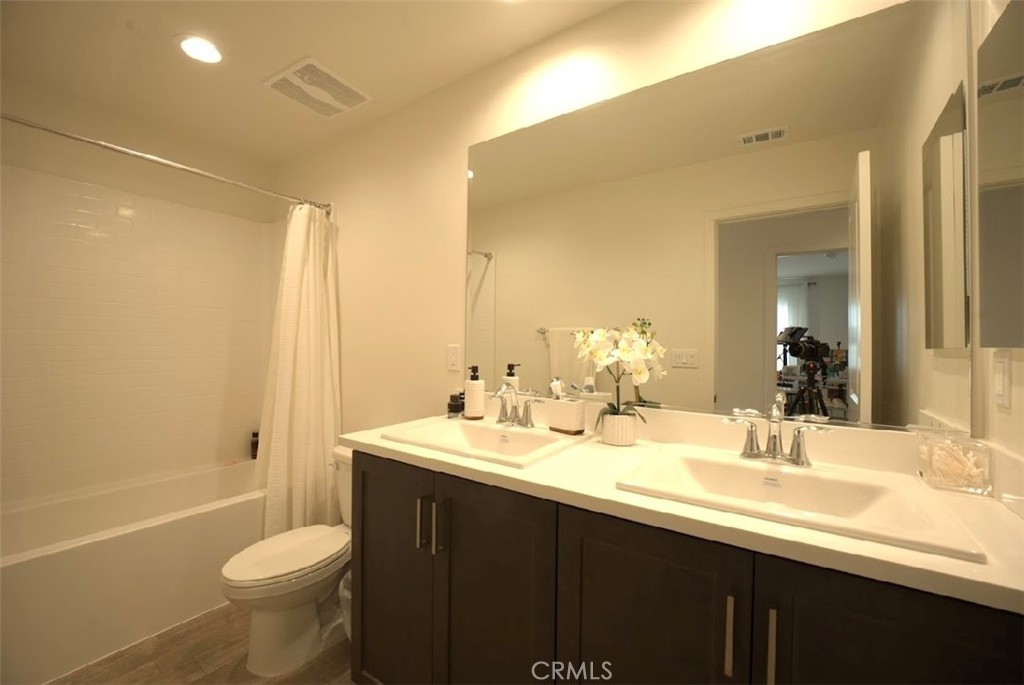 14159 Eclipse Street Moreno Valley, CA 92555 - Photo 21 of 27 a bathroom with a sink a toilet a mirror and shower