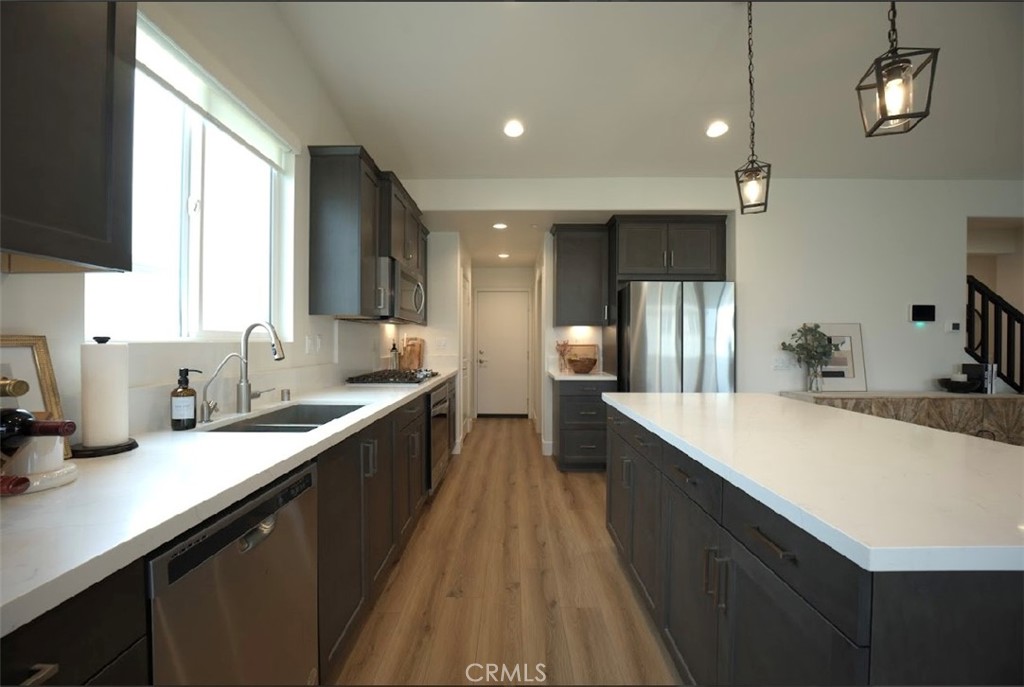 14159 Eclipse Street Moreno Valley, CA 92555 - Photo 7 of 27 a large kitchen with kitchen island a sink appliances wooden floor and a large window