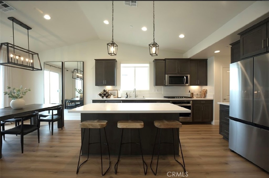 14159 Eclipse Street Moreno Valley, CA 92555 - Photo 9 of 27 a kitchen with stainless steel appliances granite countertop a table chairs refrigerator and microwave