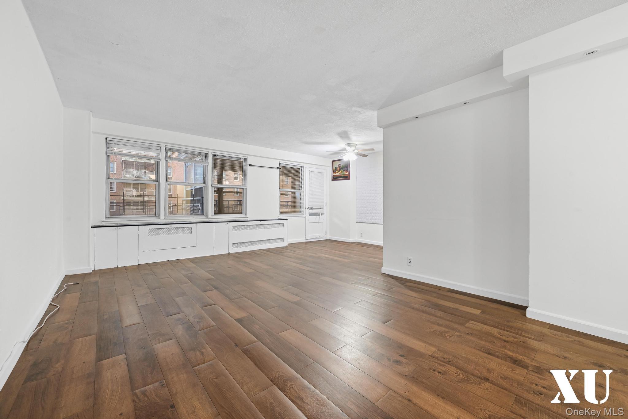 43-10 Kissena Boulevard, Unit 2B Queens, NY 11355 - Photo 3 of 23 a view of empty room with wooden floor and fan