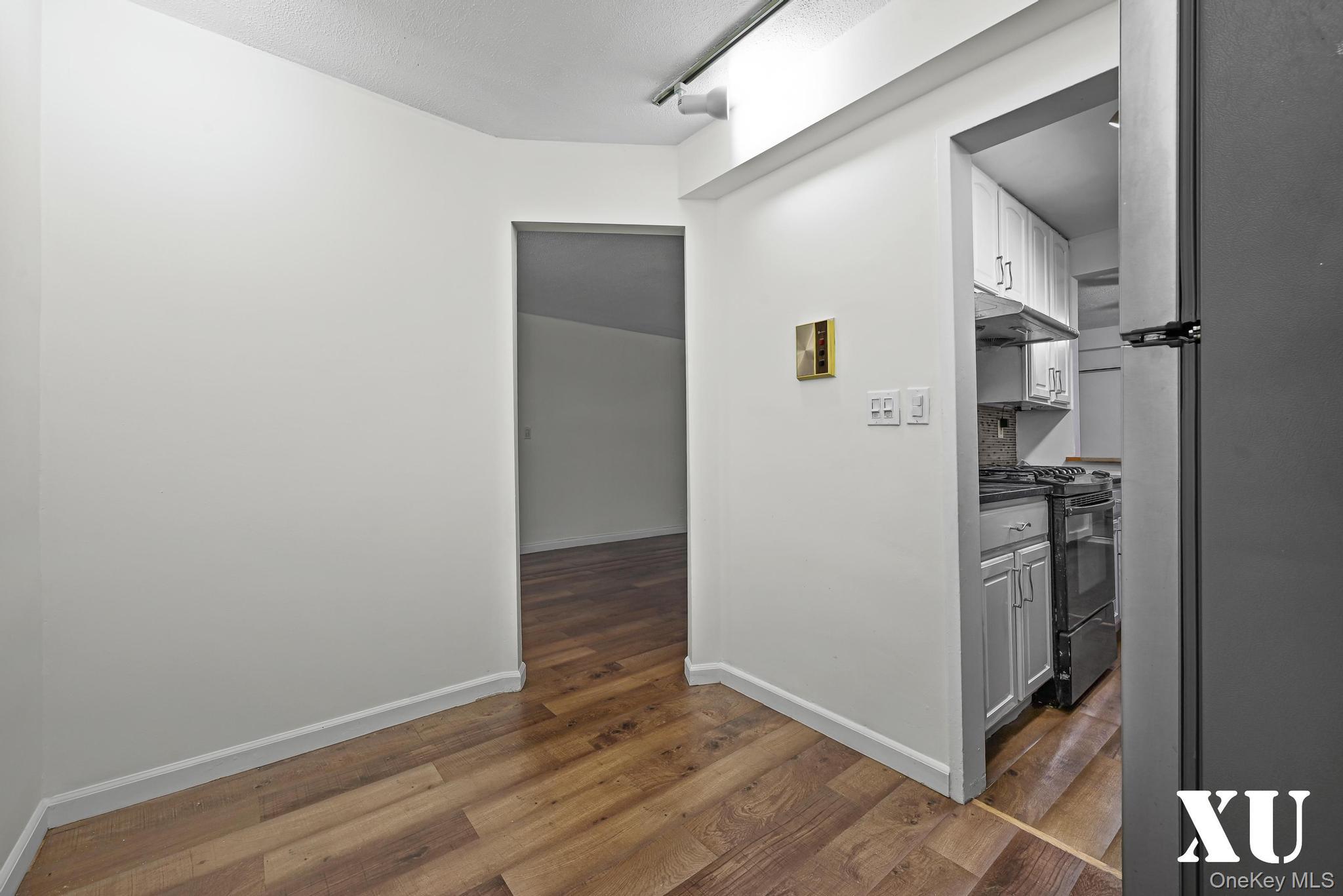 43-10 Kissena Boulevard, Unit 2B Queens, NY 11355 - Photo 6 of 23 a view of a hallway with wooden floor and a kitchen
