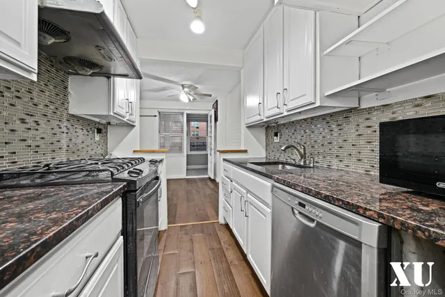 a kitchen with stainless steel appliances granite countertop a sink stove and cabinets