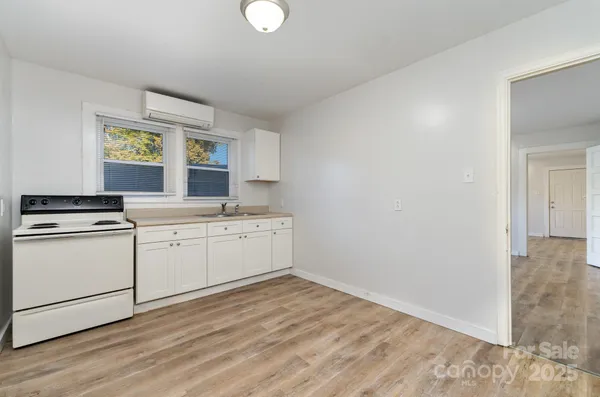 a kitchen with granite countertop a stove a sink and a microwave