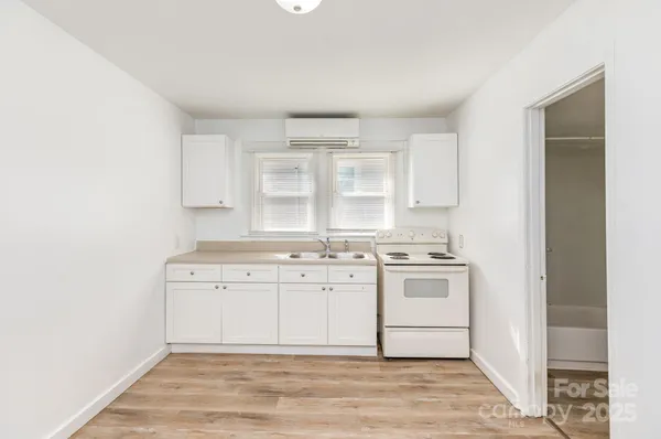 a kitchen with stainless steel appliances granite countertop a stove and white cabinets