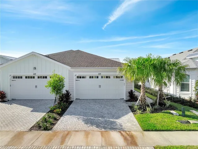 a view of a house with a yard and potted plants