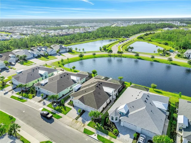 an aerial view of a house with a garden and lake view