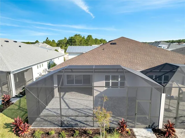 an aerial view of a house with swimming pool and ocean view