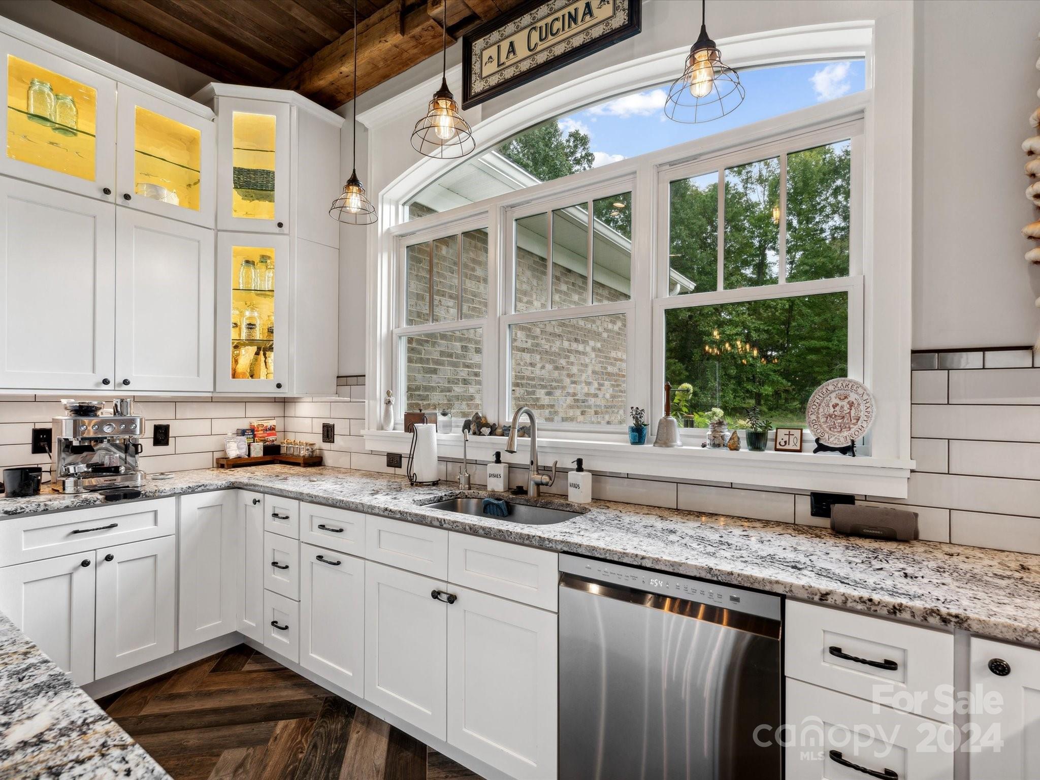 1156 Williams Road Fort Mill, SC 29715 - Photo 15 of 44 a kitchen with granite countertop a sink stainless steel appliances wooden floor and a large window