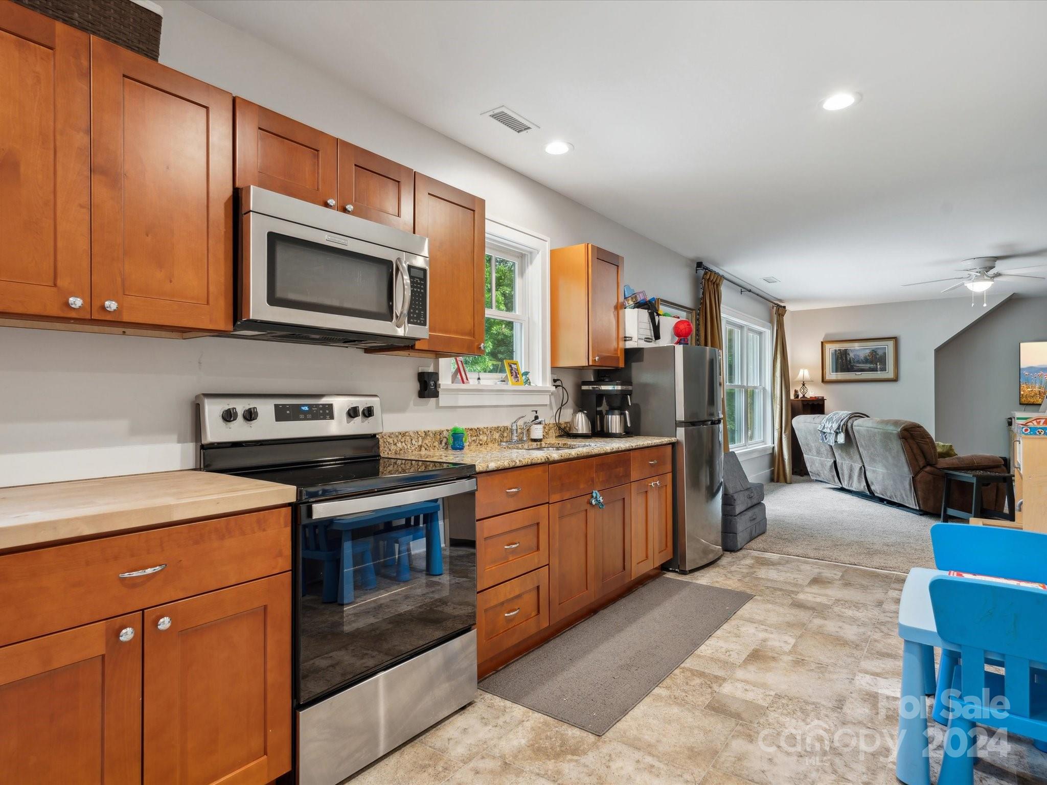 1156 Williams Road Fort Mill, SC 29715 - Photo 27 of 44 a kitchen with stainless steel appliances granite countertop a stove top oven a sink dishwasher and a microwave oven on the blue kitchen countertops