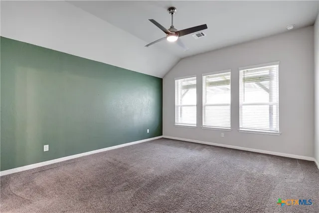 an empty room with a window and ceiling fan