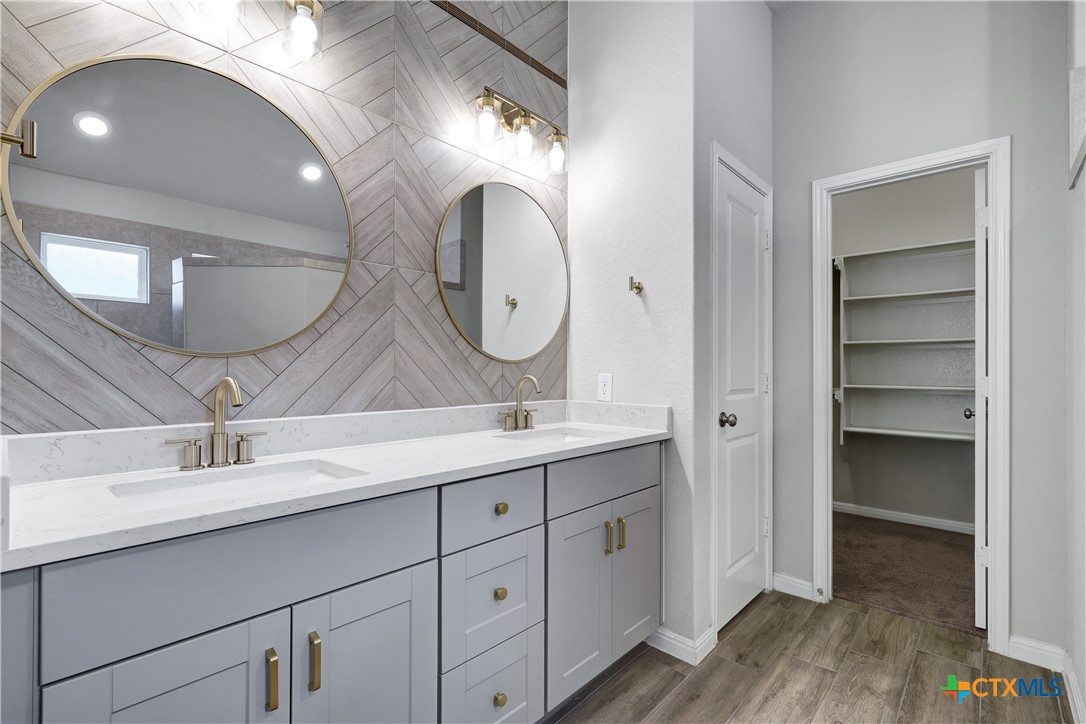 32144 Cardamom Way Bulverde, TX 78163 - Photo 14 of 30 a bathroom with a double vanity sink and a mirror