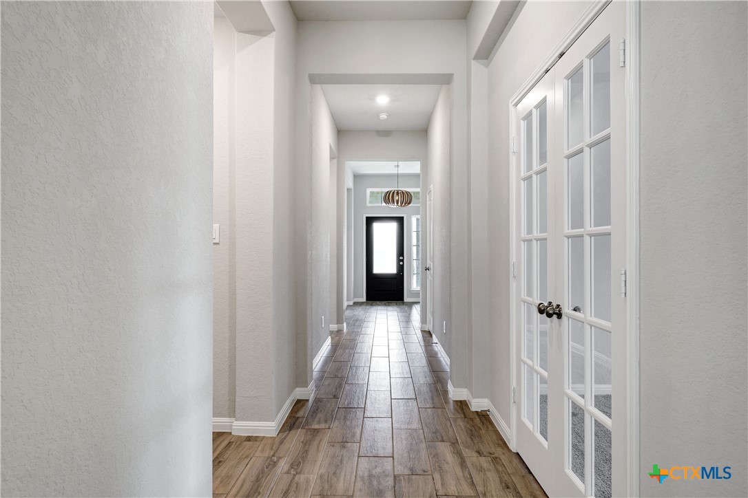 32144 Cardamom Way Bulverde, TX 78163 - Photo 2 of 30 a view of a hallway with wooden floor and a bathroom