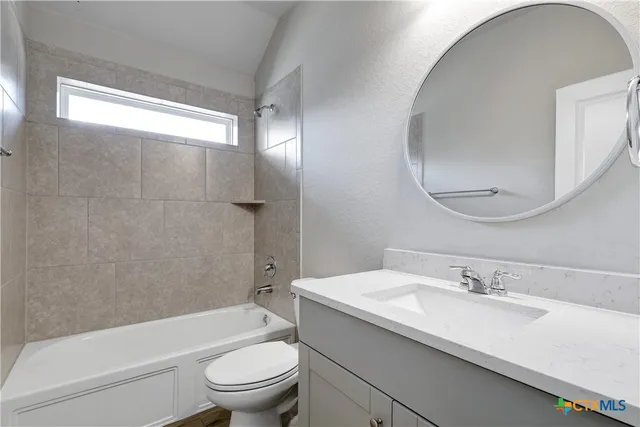 a bathroom with a granite countertop toilet a sink and a bathtub