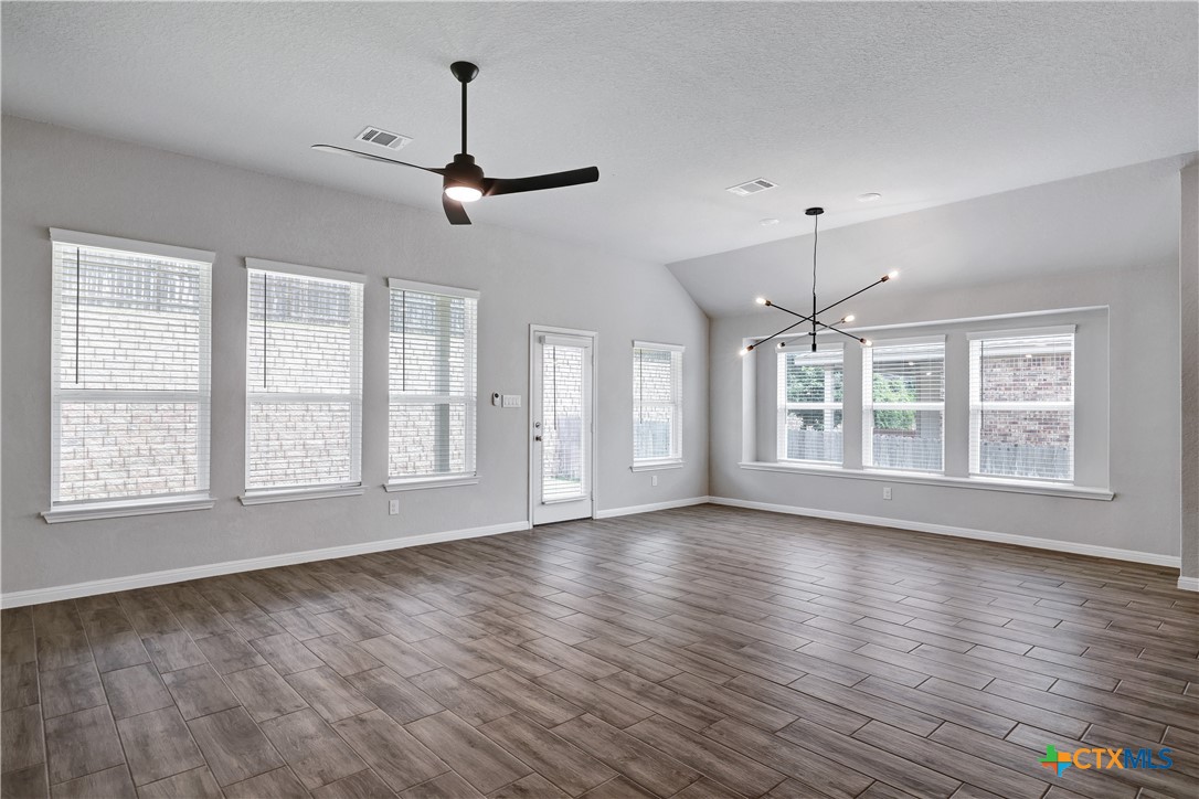32144 Cardamom Way Bulverde, TX 78163 - Photo 7 of 30 a view of an empty room with wooden floor and a window