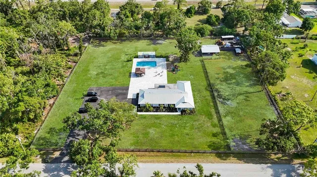 an aerial view of a house with a yard lake lake view and mountain view