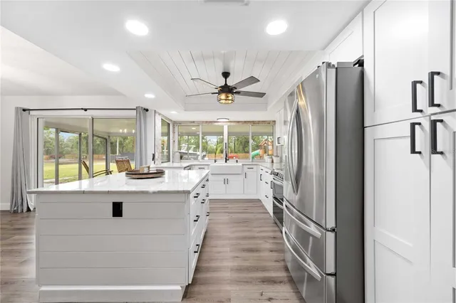 a view of kitchen with sink and refrigerator