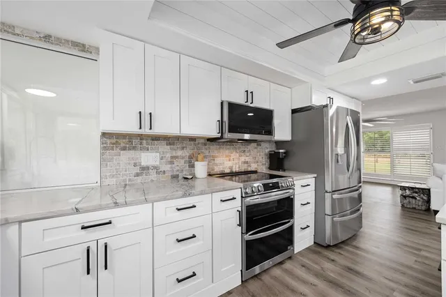 a kitchen with stainless steel appliances a stove a refrigerator and a sink