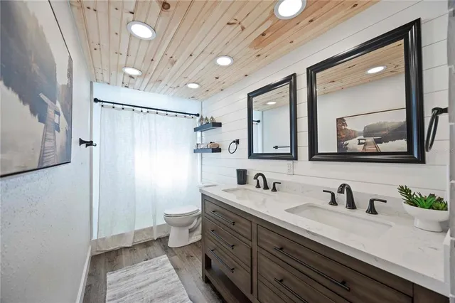 a bathroom with double vanity sink a mirror and a shower