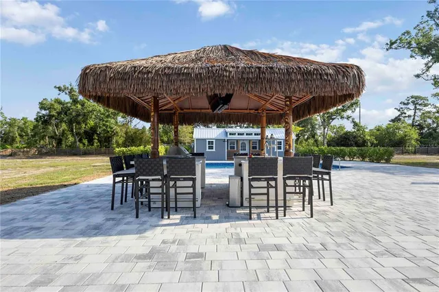 a view of a patio with a table and chairs under an umbrella