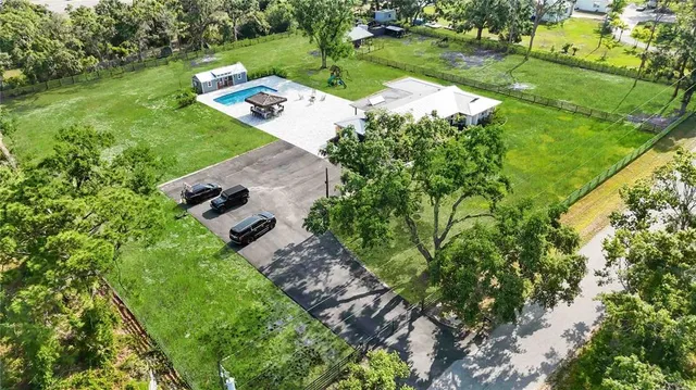 an aerial view of a house with yard basket ball court and outdoor seating