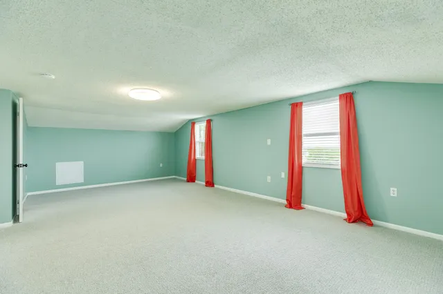 an empty room with an entryway and fan
