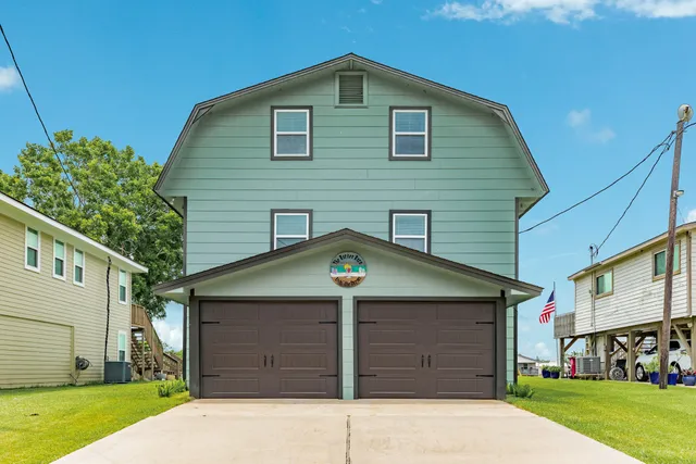 an aerial view of residential houses with outdoor space and lake view