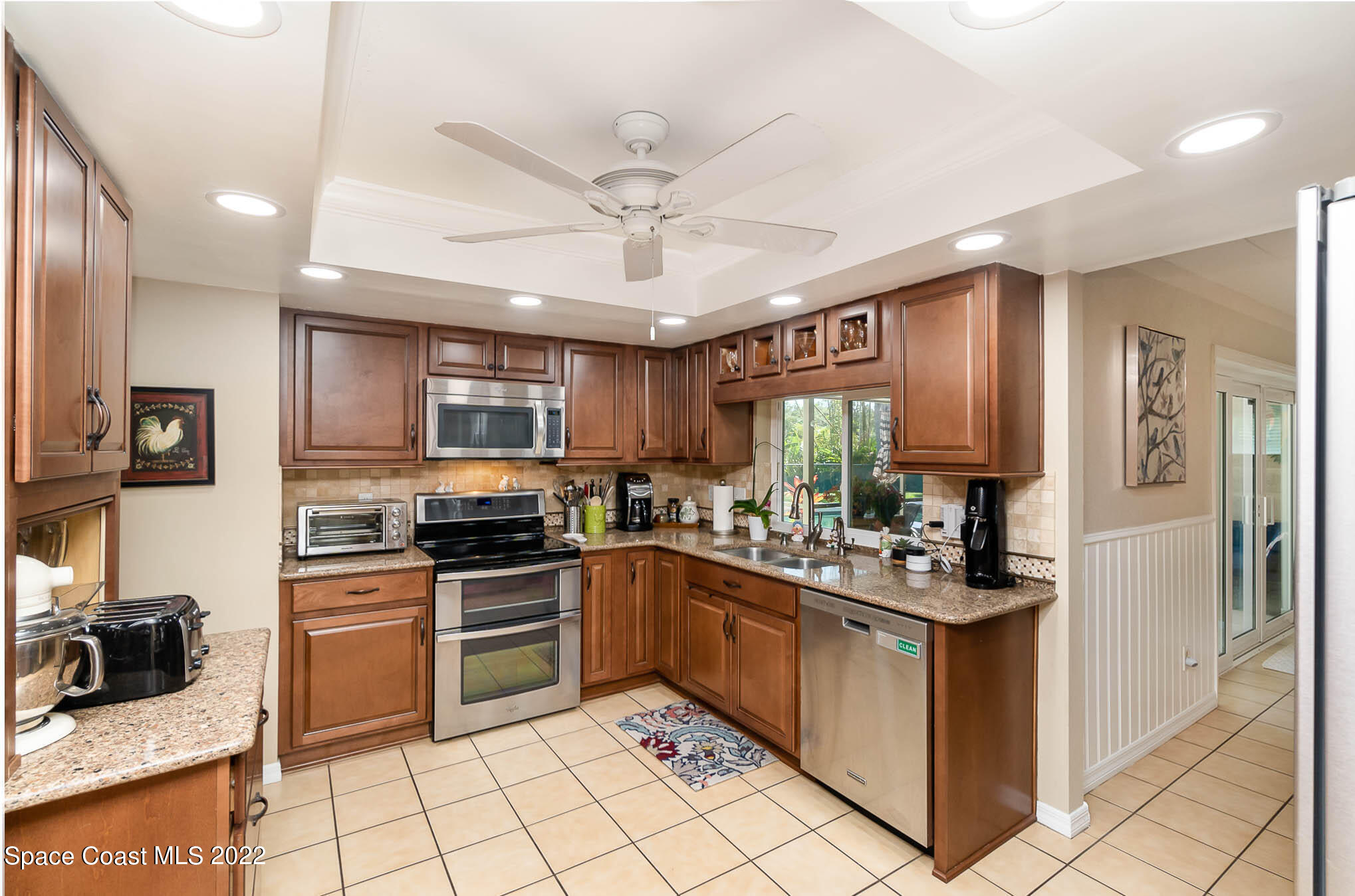 1496 Meadowbrook Road Northeast Palm Bay, FL 32905 - Photo 18 of 25 a kitchen with stainless steel appliances granite countertop a stove top oven a sink a refrigerator and cabinets