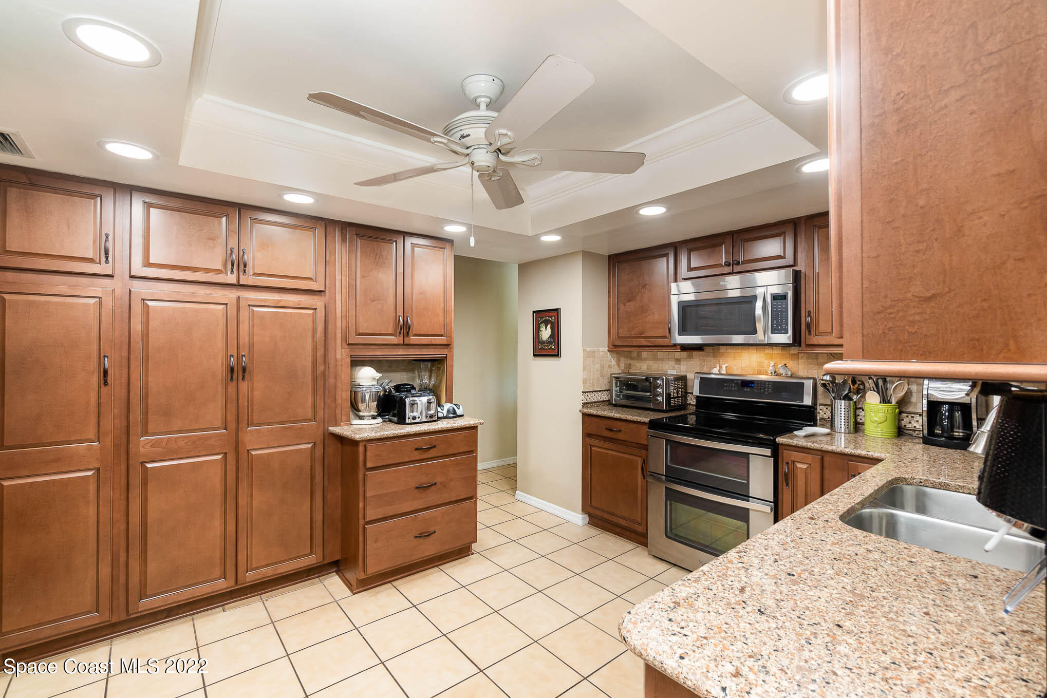 1496 Meadowbrook Road Northeast Palm Bay, FL 32905 - Photo 20 of 25 a kitchen with stainless steel appliances granite countertop a refrigerator stove top oven and sink