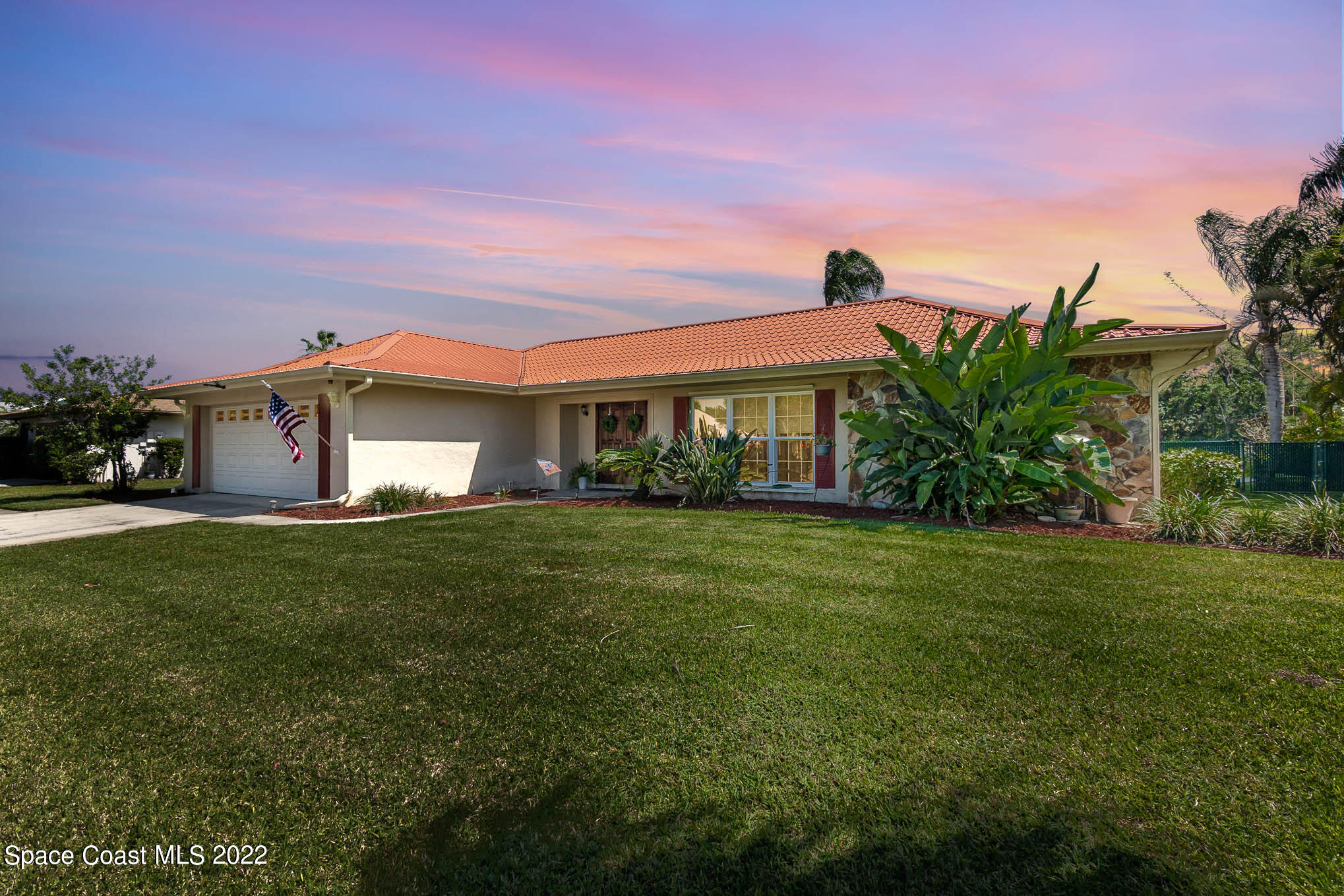 1496 Meadowbrook Road Northeast Palm Bay, FL 32905 - Photo 5 of 25 a front view of a house with a garden and yard