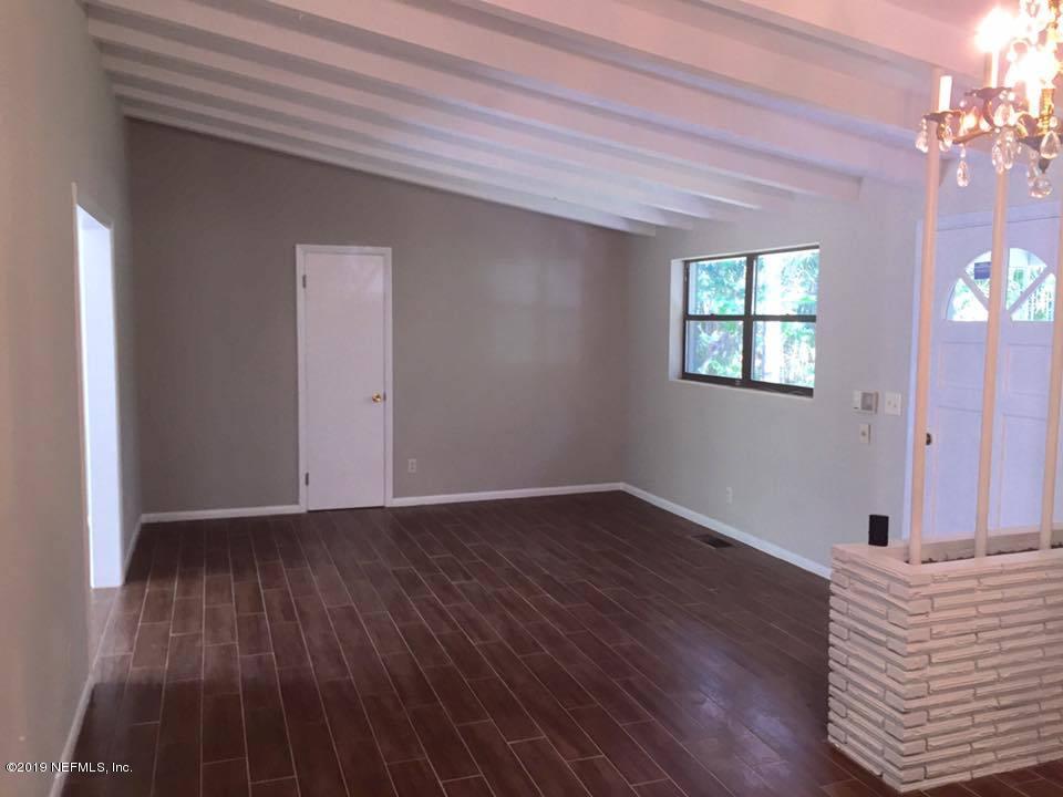 5107 Spring Glen Road Jacksonville, FL 32207 - Photo 15 of 16 a view of an empty room with wooden floor and a window